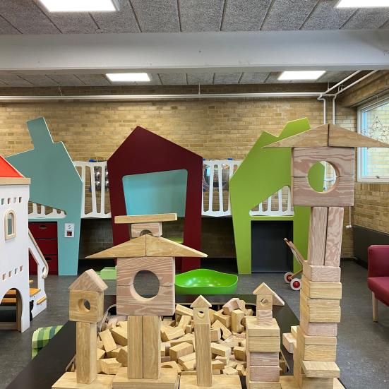 Billedet viser en legekrog på Varde Bibliotek. Nogle har bygget store tårn af klodser.