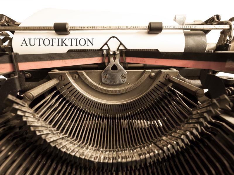 Billedet er et supernærbillede af en gammeldags skrivemaskine, hvor teksten på papiret lyder: Autofiktion