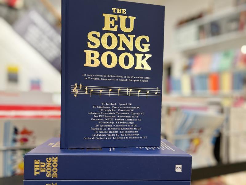 Fotoet viser en stak EU Song Books. Den øverste har forsiden vendt fremad